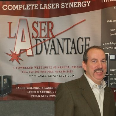 Man smiling in front of Laser Advantage sign.